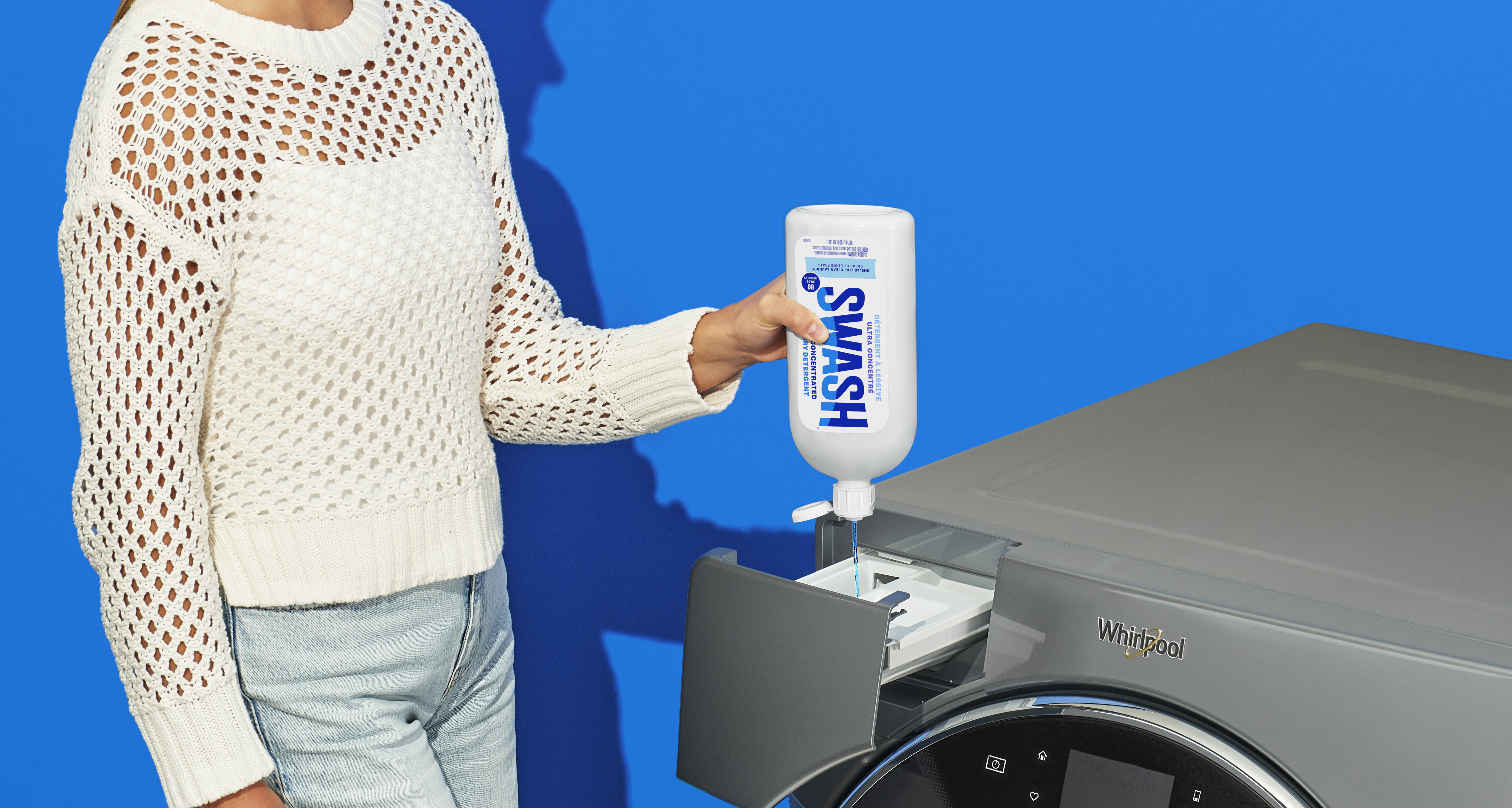 Une image sur sur fond bleu d'une personne qui verse du détergent d'une bouteille de Swash dans le distributeur de détergent d'une laveuse Whirlpool.. 