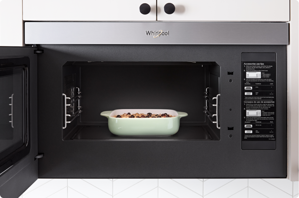 L'intérieur d'un four à micro-ondes Whirlpool ouvert dans lequel on trouve un plat à gratin