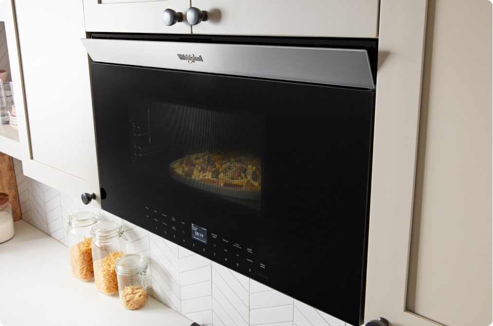 A Whirlpool Over-the-Range Microwave with a flush design in the middle of operation