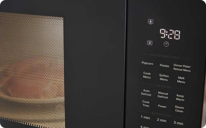 Un four à micro-ondes Whirlpool en train de décongeler du poulet. L'heure indique : « 9:28 »