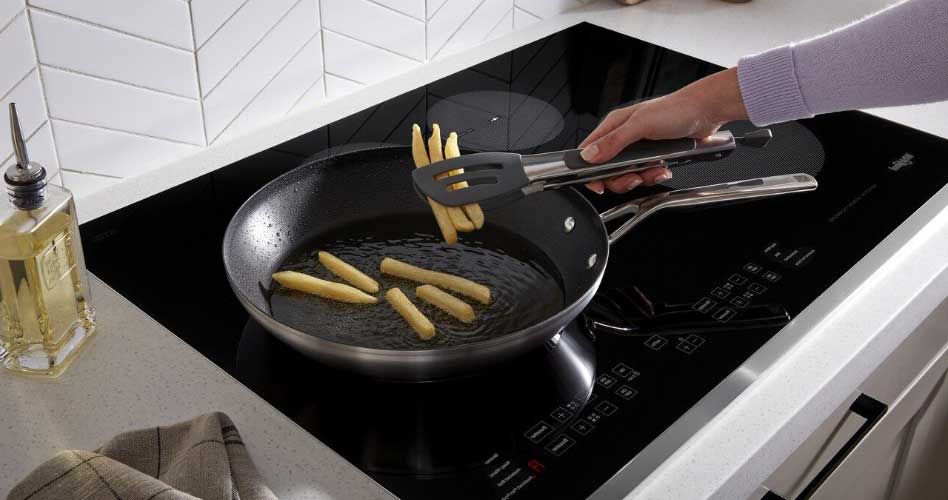 Whirlpool Combination Microwave Man cooking french fries on a Whirlpool cooktop