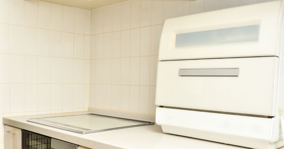 A countertop dishwasher on a white kitchen counter.