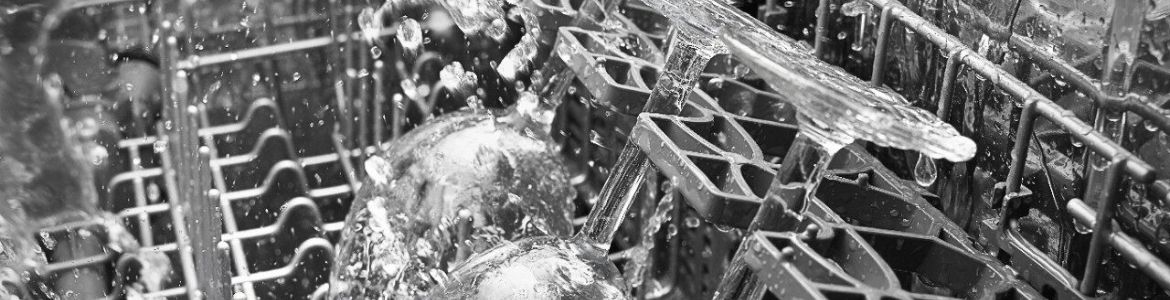 Inside a Whirlpool dishwasher that is in operation. Three glasses are being sprayed with water.