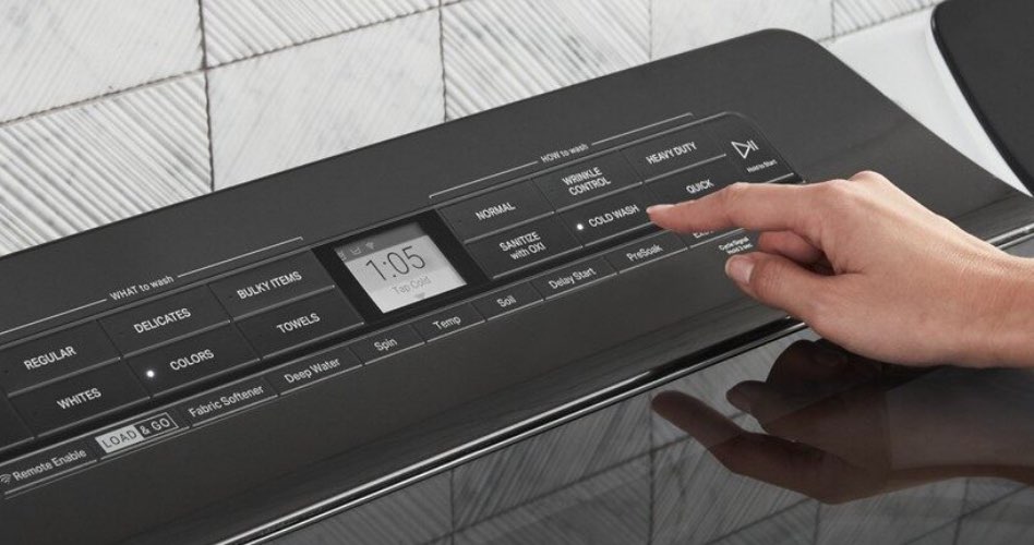 Whirlpool Combination Microwave A hand about to press a button on the black control panel of a washing machine. The time on the machine reads, 1:05