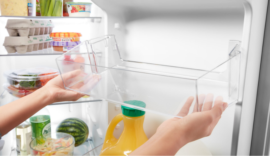 Whirlpool Combination Microwave A homeowner is placing an adjustable door bin inside the refrigerator