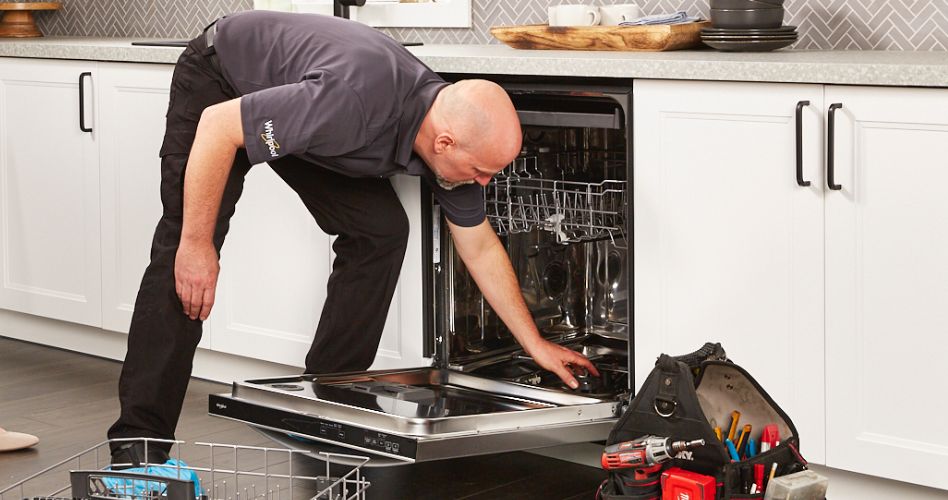 Whirlpool Combination Microwave An appliance repairman inspects the filter of a Whirlpool dishwasher. Their toolbox is on the floor and a dishwasher rack is in front of the appliance.