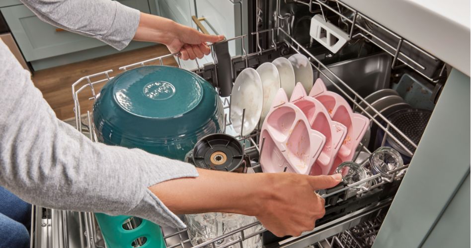 Whirlpool Combination Microwave Someone pulling out a dishwasher rack. On the rack are a mixing bowl, plates, kids' plates and glasses.