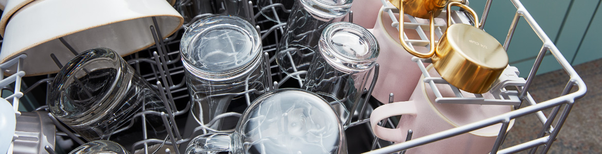 Various dishes loaded in the top rack of a dishwasher