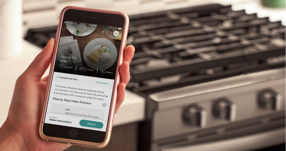 Whirlpool Combination Microwave Someone holding a smartphone that's open to the Whirlpool app. A Whirlpool range is in the background.