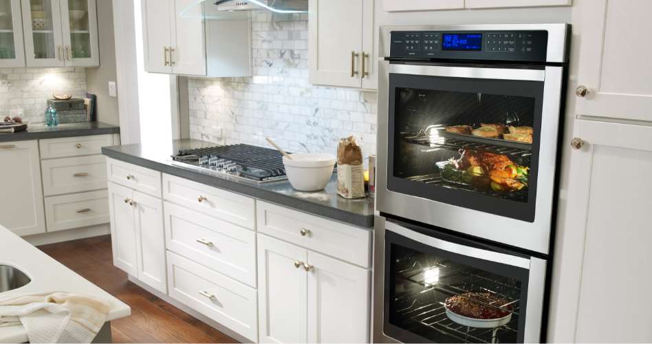 Whirlpool Combination Microwave Un four mural double Whirlpool en acier inoxydable encastré dans une armoire de cuisine avec des comptoirs blancs