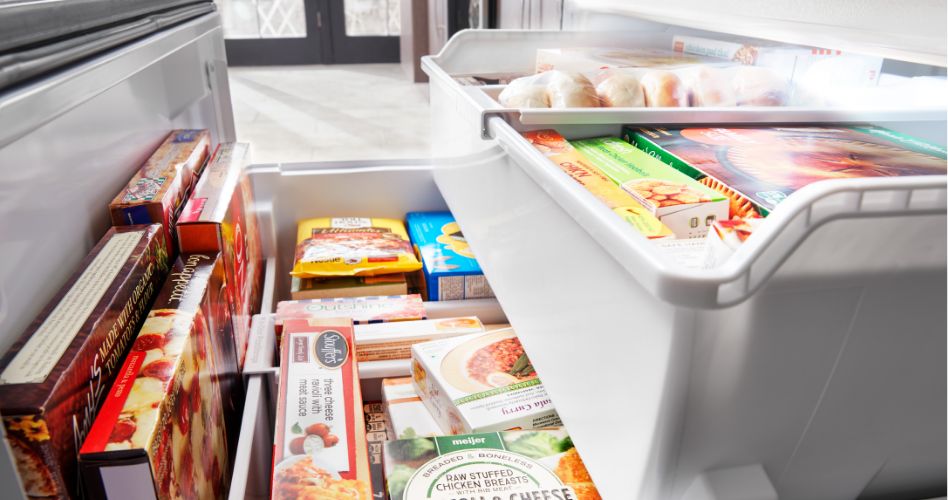 Un congélateur contenant une variété d'aliments congelés répartis sur deux niveaux