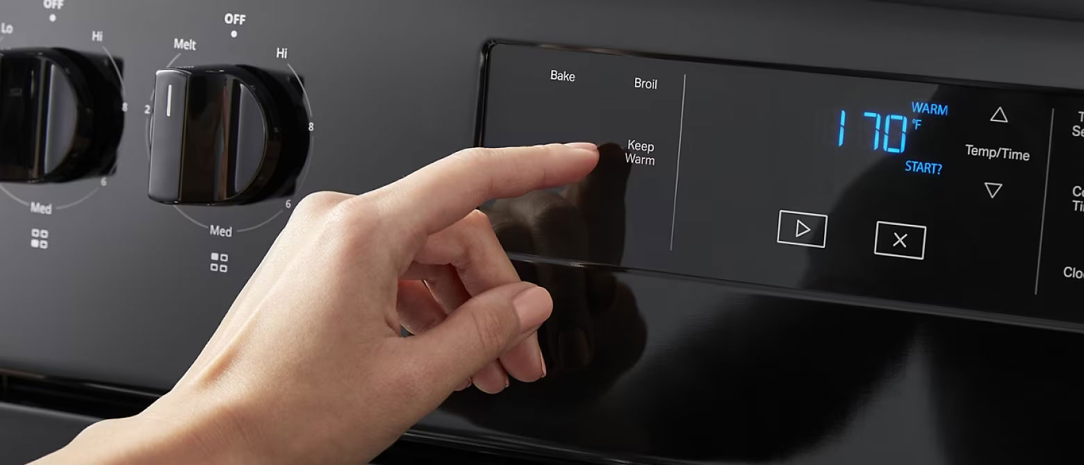 Whirlpool Combination Microwave Le panneau de commande d'un four Whirlpool. Une personne appuie sur le bouton Keep Warm garder au chaud. Les deux boutons sont tournés à  OFF . L'écran affiche 170 degrés Fahrenheit,  WARM » et « START?