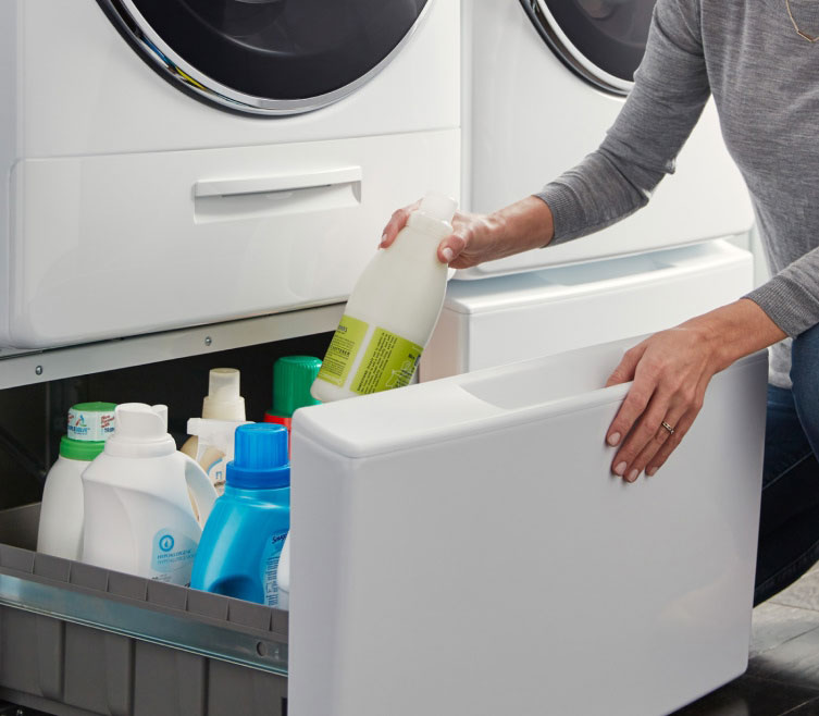 A Whirlpool® Front Load Washer and Dryer side-by-side on top of laundry pedestals