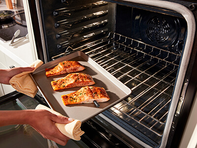 Putting salmon into the oven Putting salmon into the oven