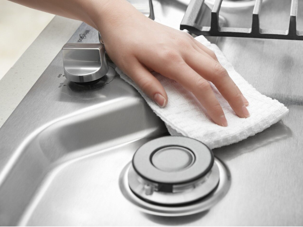 Une personne essuie une plaque de cuisson à la main.