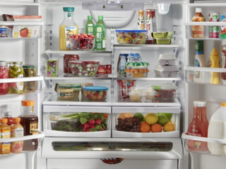 Open French door refrigerator filled with food
