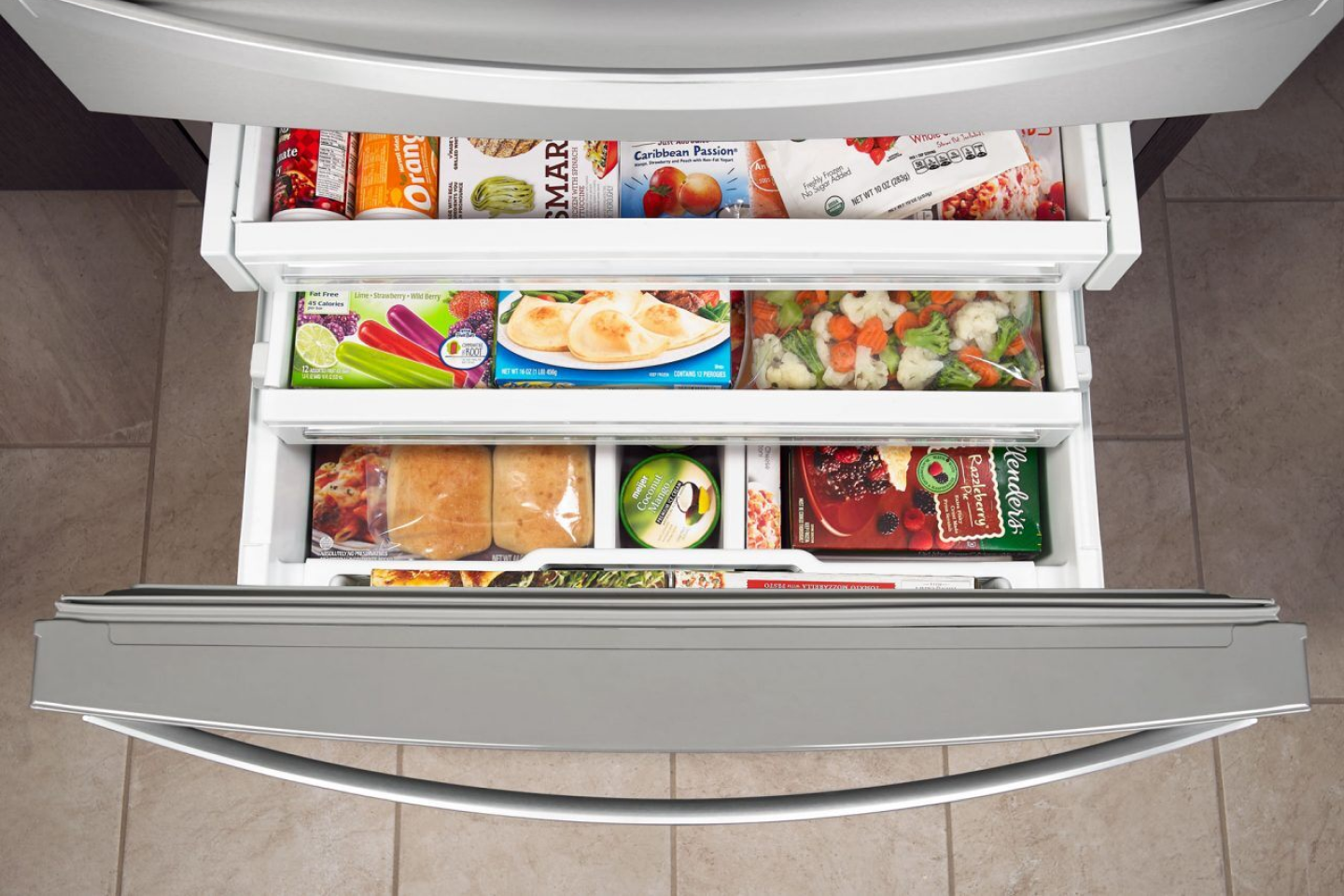 Birds-eye view of tiered shelving holding frozen goods in a bottom freezer Vue du haut d'étages contenant des aliments surgelés dans le congélateur inférieur d'un réfrigérateur.