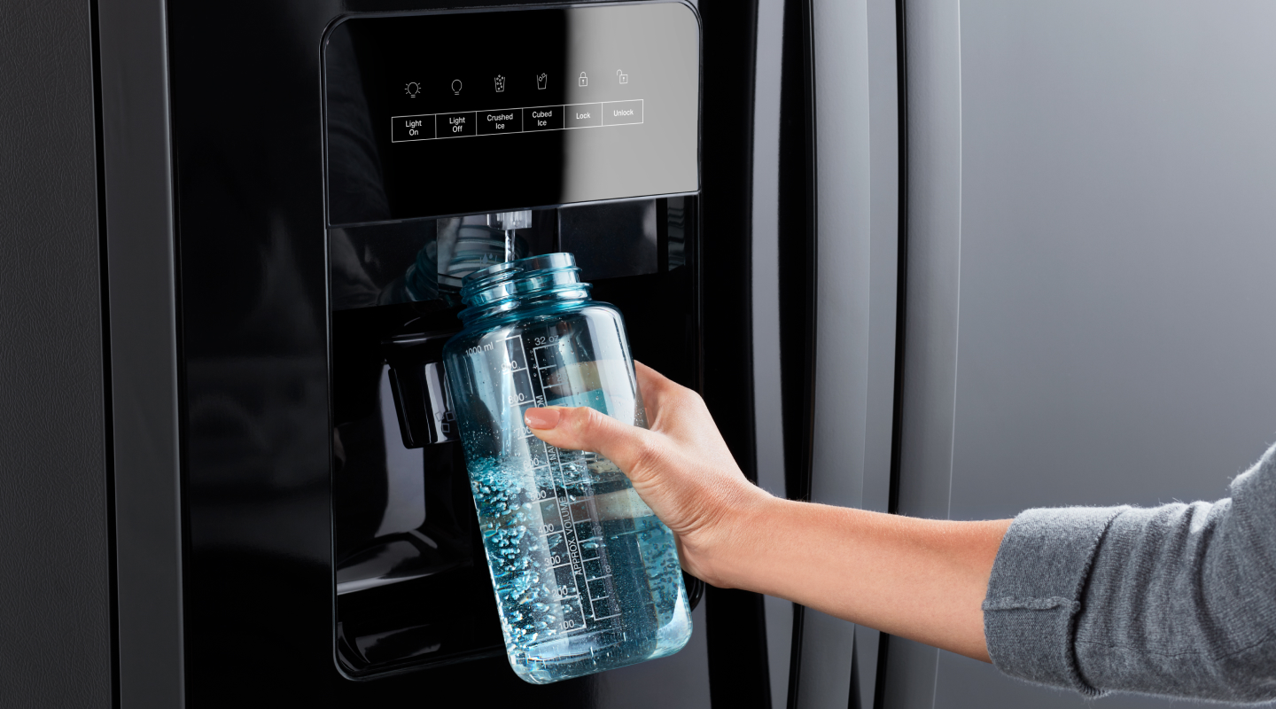 Person filling up a water bottle with an in-door water dispenser