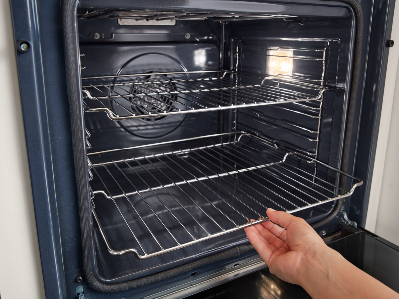 Person removing an oven rack from a Whirlpool® oven Person removing an oven rack from a Whirlpool® oven