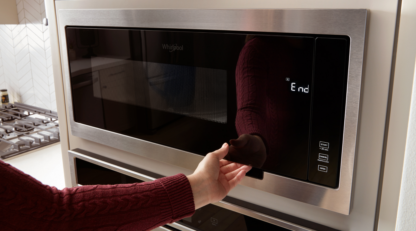 Person opening microwave cavity of Whirlpool® Combination Wall Oven Person opening microwave cavity of Whirlpool® Combination Wall Oven