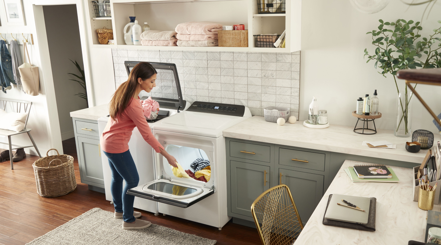 Person moving laundry from washer to dryer