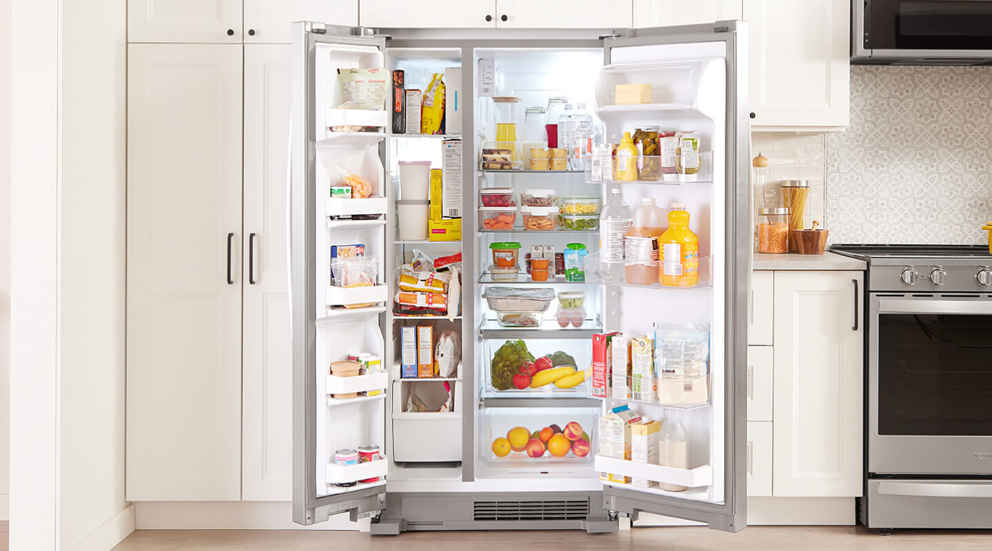 Un réfrigérateur côte à côte dont les deux portes s'ouvrent pour révéler un intérieur bien rempli