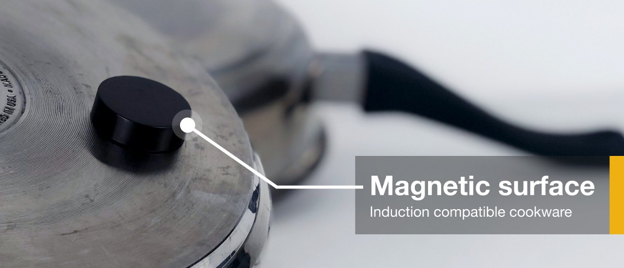 A magnet stuck to the bottom of induction compatible cookware A magnet stuck to the bottom of induction compatible cookware