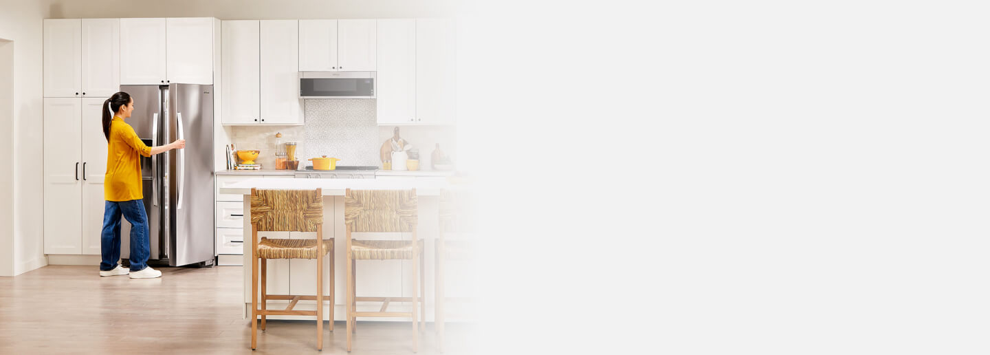 Personne ouvrant un réfrigérateur côte à côte