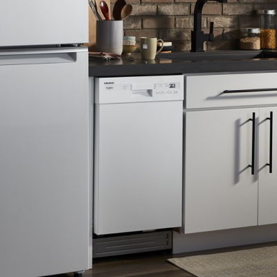 A white Whirlpool® Dishwasher in a kitchen with a white refrigerator