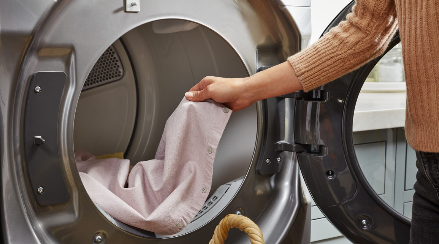 Person removing clothing from a dryer