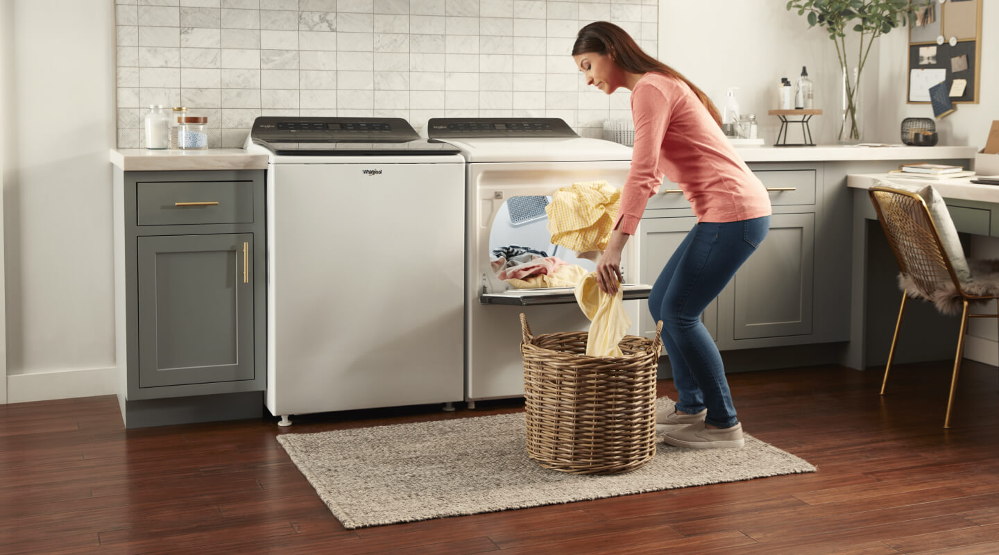 Person unloading clothes from a Whirlpool® Dryer