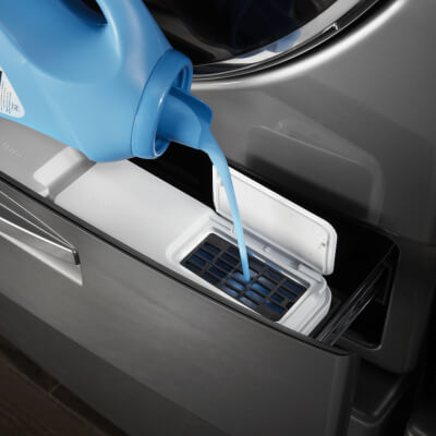 Fabric softener being added to the inside of the washer