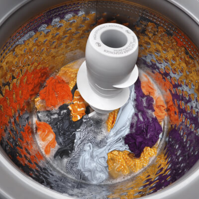 Bright load of clothing soaking inside a top load washer
