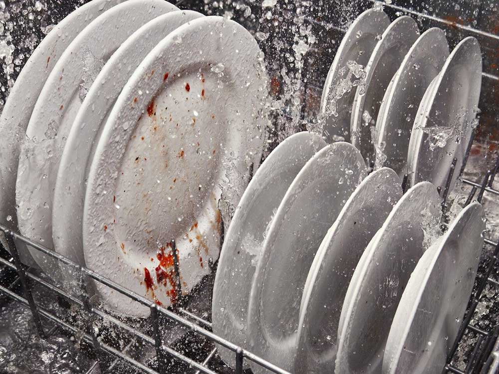 Dishes being cleaned during a dishwasher cycle. Dishes being cleaned during a dishwasher cycle.
