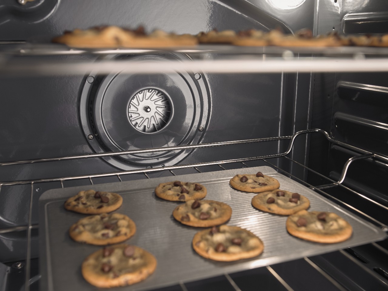 Cookies baking on two separate racks in an oven Cookies baking on two separate racks in an oven