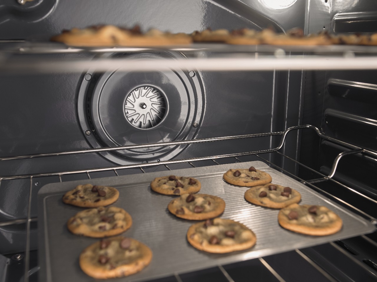 Cookies baking on two separate racks in an oven