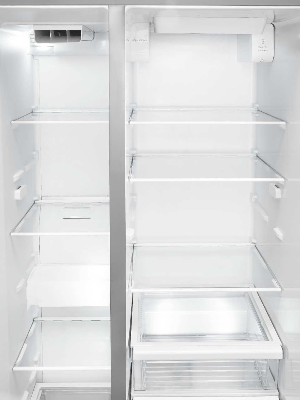 The inside of an empty stainless steel refrigerator.