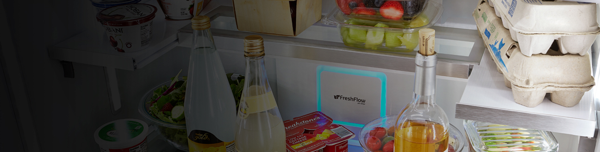 The interior of a refrigerator organized with fresh food, beverages and produce.