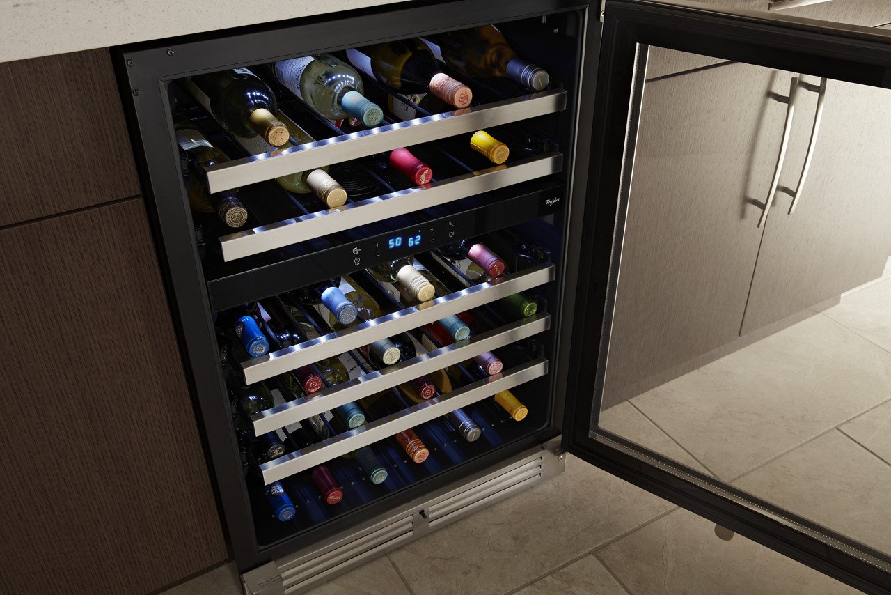 An undercounter wine refrigerator in a kitchen. An undercounter wine refrigerator in a kitchen.