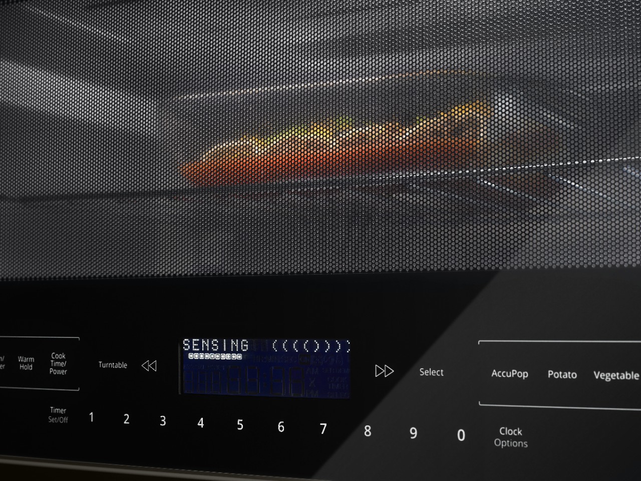 A casserole dish heating in a microwave.