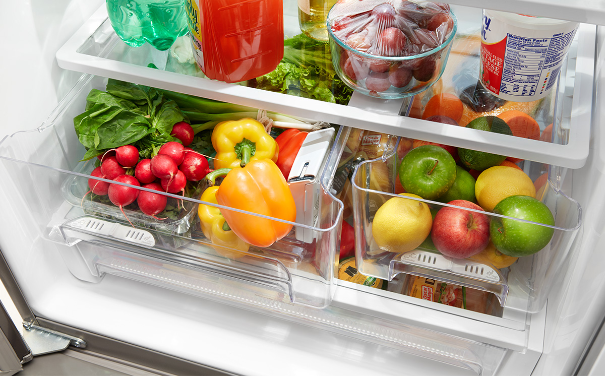 A clean fridge interior with fresh fruit and produce.