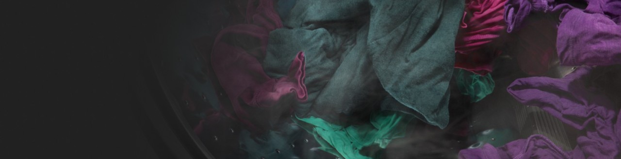 Dark purple and green clothes spinning in a washer