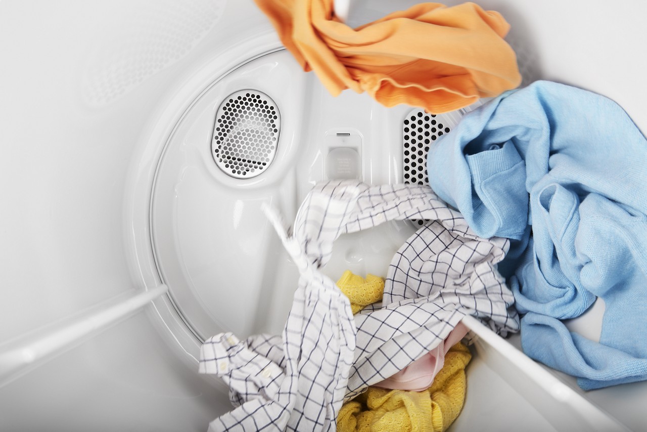 Clothes tumbling in a dryer drum during a dry cycle.