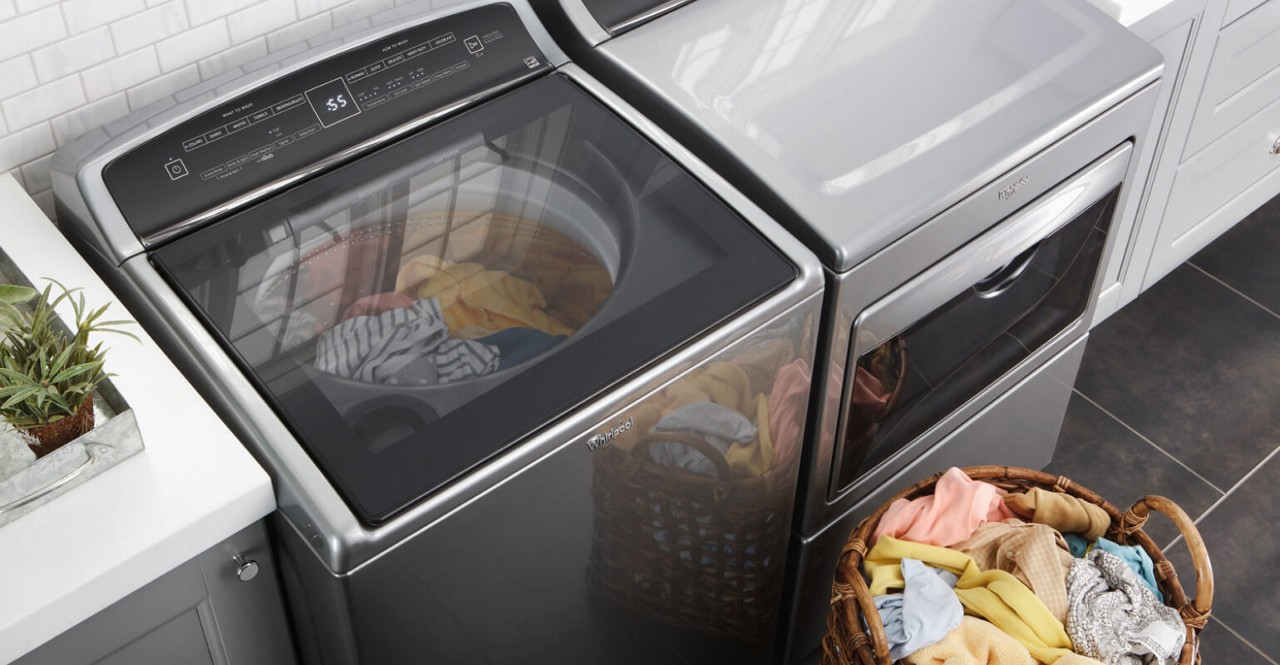 A person rinses a striped garment using their washing machine.