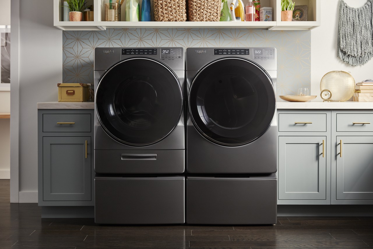  A side-by-side, front load washer dryer set in a laundry room.