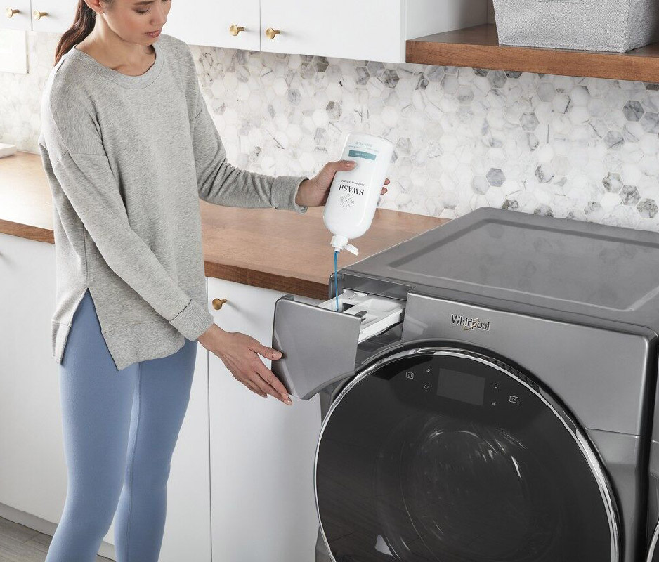 Woman using Swash detergent in wahsing machine Woman using Swash detergent in wahsing machine