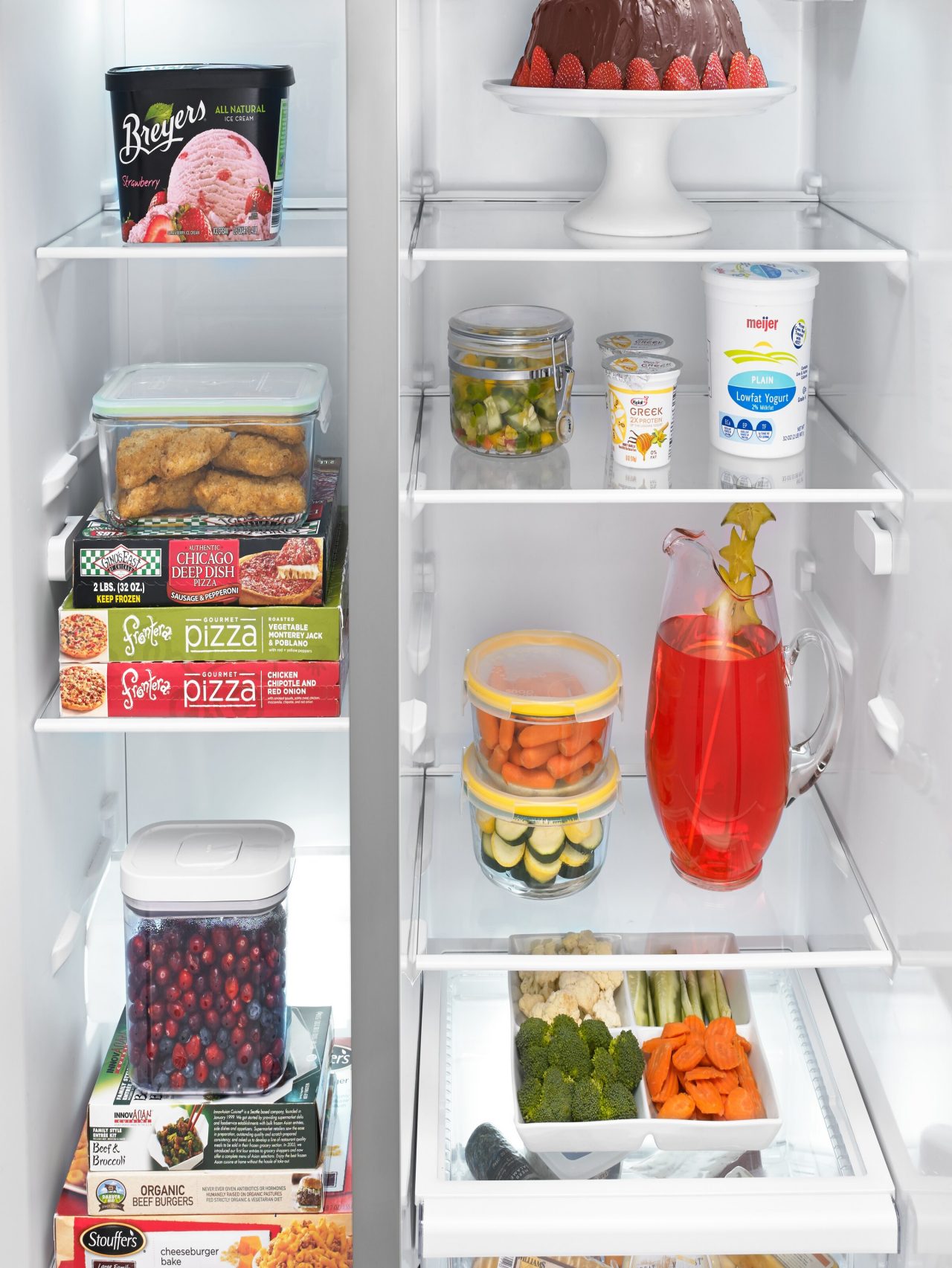 An open refrigerator displays numerous frozen and fresh foods.