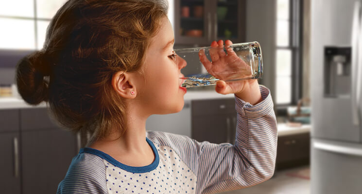 Jeune fille buvant un verre d’eau
