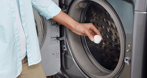 Une femme nettoie sa machine à laver Whirlpool