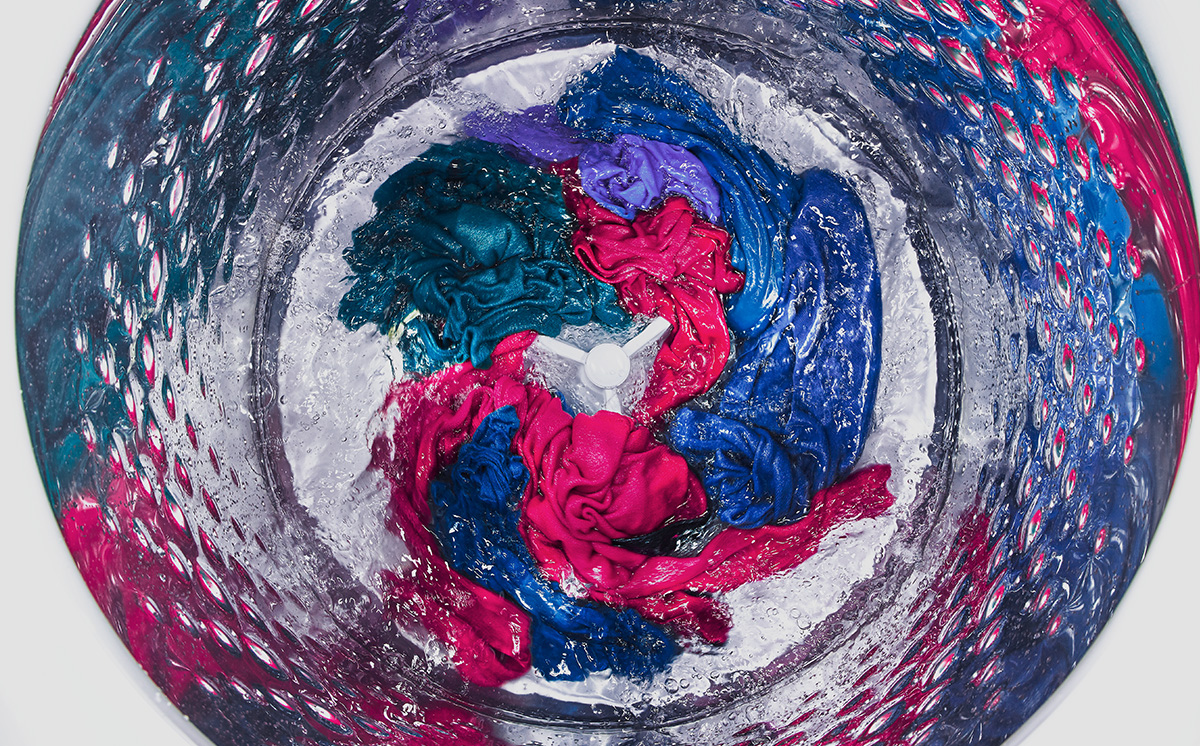 A load of colorful clothing going through a spin cycle. A load of colorful clothing going through a spin cycle.